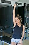 Pretty woman lifting weights in gym