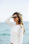 Pretty blonde woman with sunglasses at the beach