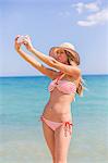 Pretty woman doing a selfie at the beach