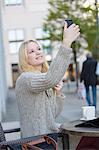 Pretty young woman doing a selfie in a Cafe in city center