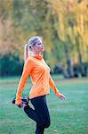 Pretty blonde woman stretching in park