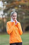 Portrait of a pretty blonde woman doing sport in park smiling at camera