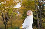 Pretty blonde woman with coat in Park in Autumn