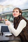 Daydreaming woman enjoying a coffee outdoors