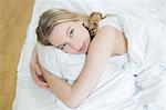 Pretty blonde woman in bed looking at camera