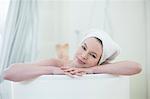 Pretty blonde woman enjoying a bath looking at camera