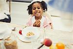 Portrait smiling girl eating breakfast at table