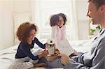 Daughters serving coffee and card to father in bed on Father's Day