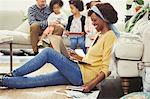 Smiling mother with laptop paying bills online with family in background