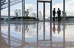 Businessmen handshaking in highrise office with urban city view, London, UK