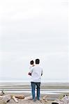 Father holding on on overcast beach