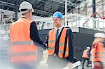 Male engineers handshaking at construction site