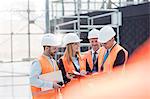 Foreman and engineers discussing paperwork at construction site