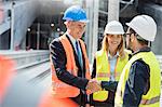 Businessman and engineer handshaking at construction site