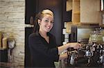 Portrait of waitress using the coffee machine in cafe