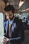 Businessman checking time on smartwatch while travelling in train