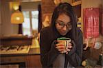 Woman having coffee in kitchen at home