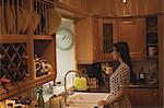 Woman having coffee in kitchen at home