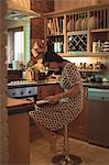 Woman reading a book in kitchen at home