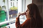 Beautiful woman having coffee at window in the restaurant