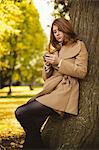 Beautiful woman using mobile phone while standing in the park
