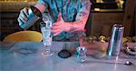 Bartender preparing a drink at counter in bar