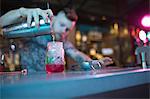 Bartender preparing cocktail at counter in bar