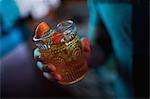 Man holding a glass of orange cocktail in bar