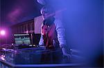 Pretty female dj playing music in bar