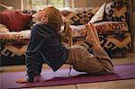 Girl performing yoga in living room at home