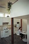 Woman using digital tablet in kitchen at home