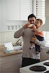 Father feeding his baby in kitchen