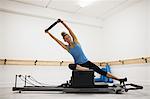 Woman exercising with pilates ring in gym