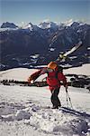 Skier walking in snow alps with ski during winter