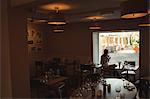 Thoughtful woman having cup of coffee near window at café