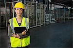 Portrait of beautiful young woman holding digital tablet in warehouse