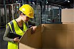 Female worker checking products in box at warehouse