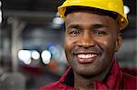 Close up portrait of male worker wearing yellow hard hat at factory