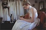 Young bride using mobile phone in a boutique