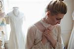 Thoughtful young bride standing in boutique