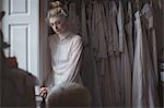 Portrait of young bride standing near window in a boutique