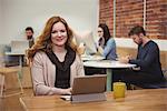 Female executive using digital tablet at desk in office