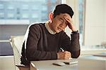 Depressed male executive sitting at desk in office