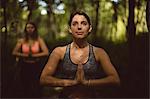 Beautiful women performing yoga in the forest