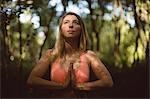 Beautiful woman performing yoga in the forest
