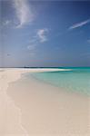 Tranquil tropical ocean beach under sunny blue sky