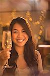 Portrait smiling Chinese woman toasting champagne flute