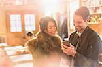 Couple using cell phone in cafe