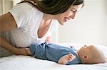 Mother playing with baby boy, face to face, smiling