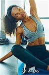 Young woman exercising in gym, stretching